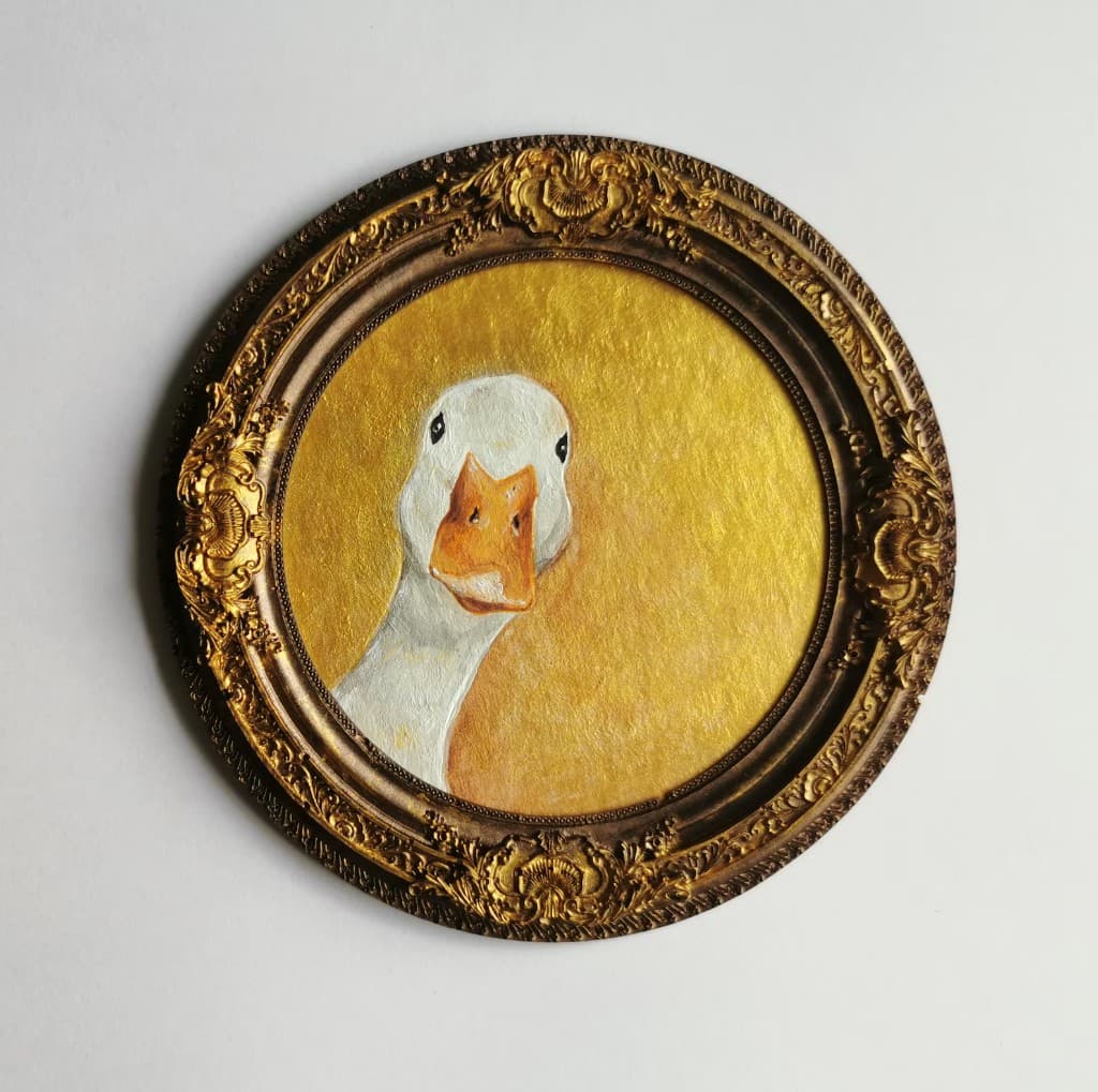 Duck portrait painting on a gold background displayed in an ornate round vintage-style frame